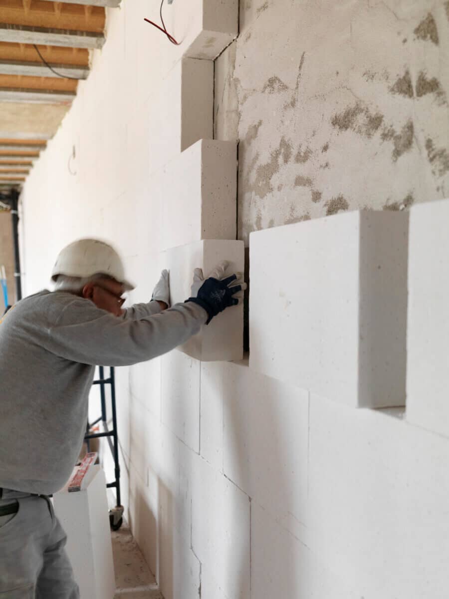 Image description: This image shows the boards being applied to the wall using the Fix X710 lime/cement adhesive.