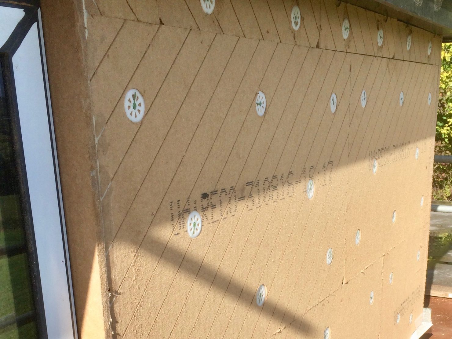 Here you can see the UdiDiffutherm wood fibre insulation reveal boards glued in to place in a window reveal within the UdiRECO system. In spite of the wall having a 200mm lean forward over it’s height, once the system was installed it’s levelling compensation made it difficult to see any lean whatsoever.