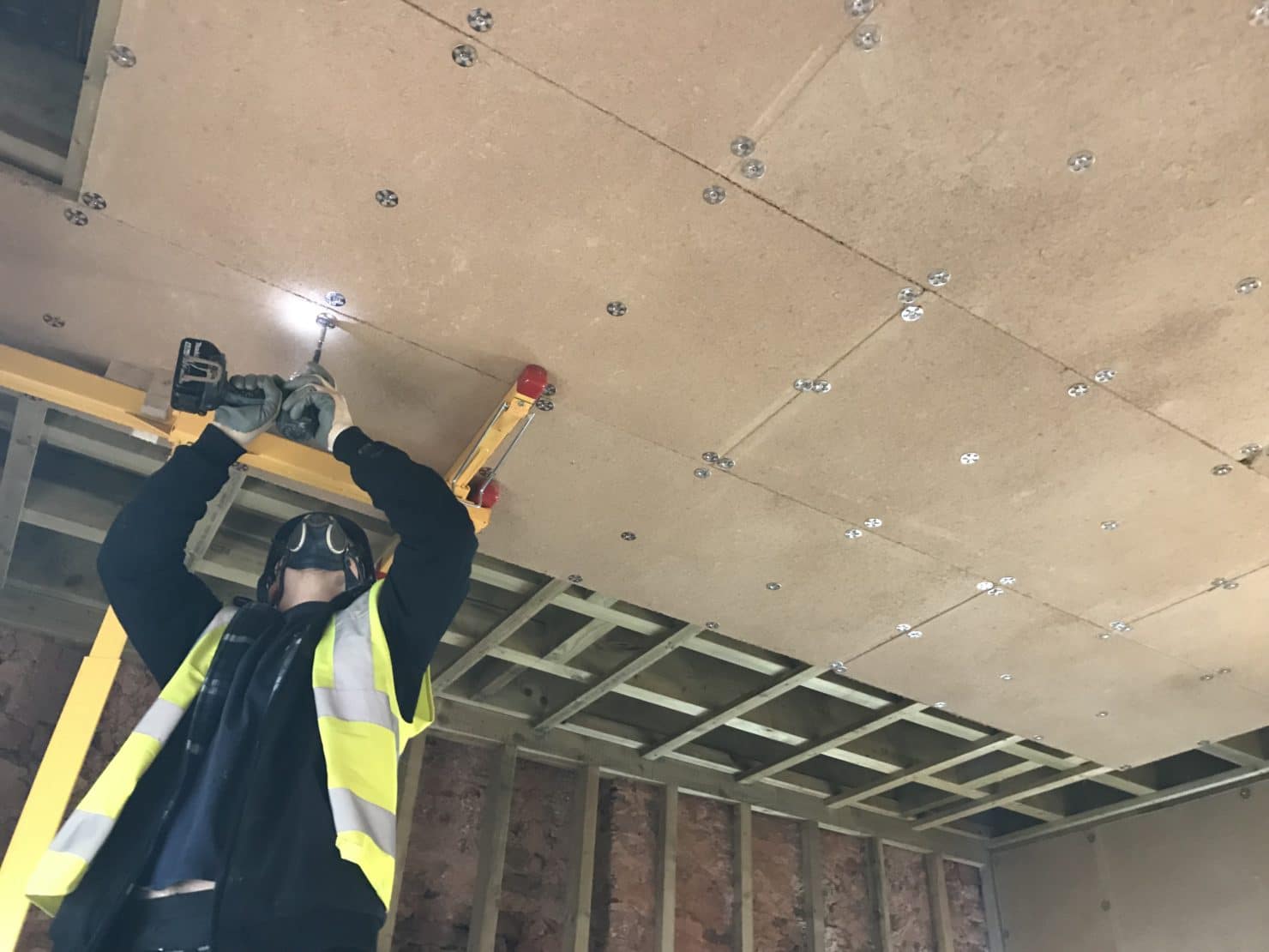 Material in action.

Here you can see the EBB clay boards being attached to a new ceiling using stainless steel screws and stainless steel washers. This is a useful image as it shows how the fixings should be spaced and how many fixing points the boards need when used on a ceiling.